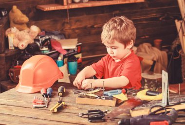 Yürümeye başlayan çocuk meşgul yüzündeki evde araçlarında atölye ile oynuyor. Çocuk Çocuk tamirci oynamak. Çocuk şirin ve sevimli araçlarla builder veya repairer oynarken, onarma veya handcrafting. Çocukluk kavramı