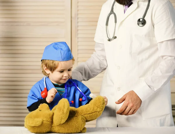 Un petit assistant fait une injection aux ours en peluche. — Photo