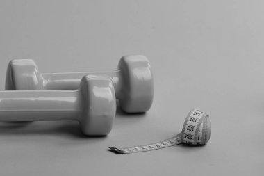 Uzun yumuşak bir cetvelle plastik halterler. Spor malzemeleri.
