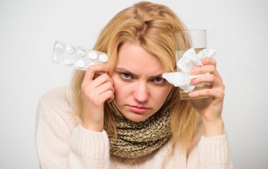 Kız ilaç alır, su içer. Baş ağrısı ve soğuk algınlığı ilaçları. Grip ve soğuk algınlığı. Eşarp tutan tabletleri tutan kadın su topladı. Soğuk algınlığını tedavi etmek için kılavuz. Soğuk algınlığından kurtulmak için ilaç al.