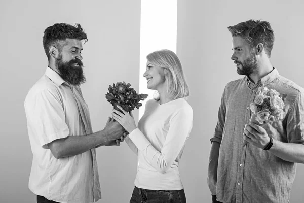 Mannen concurrenten met boeketten bloemen proberen meisje veroveren. Meisje glimlachend haar keuze gemaakt. Gebroken hart concept. Vrouw gelukkig neemt boeket bloemen romantische gift. Populaire meisje veel mannelijke aandacht krijgen — Stockfoto