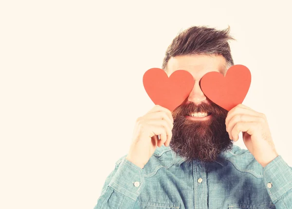 Homem com barba segura corações de papel vermelho como óculos . — Fotografia de Stock