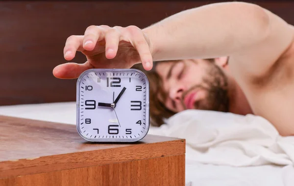 Um jovem acordando na cama e estendendo os braços. Homem sentindo dor nas costas na cama depois de dormir. Homem de manhã. — Fotografia de Stock