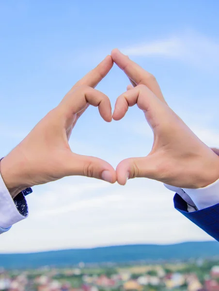 Manos masculinas en forma de corazón símbolo de gesto de amor y romance. El gesto del corazón de la mano forma usando los dedos. Manos juntas en forma de corazón fondo cielo azul. Concepto de símbolo de amor — Foto de Stock