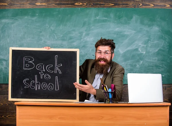 Enseignant ou directeur d'école accueille avec inscription tableau noir de retour à l'école. Début de la nouvelle année scolaire en septembre. L'enseignant accueille de nouveaux élèves dans l'établissement d'enseignement. Bienvenue à nouveau — Photo