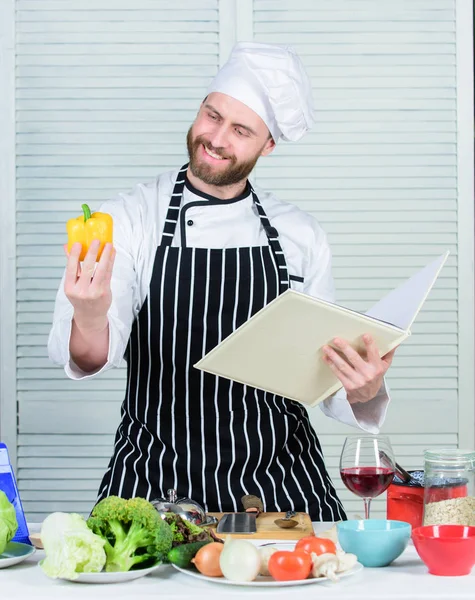 Adam şef yemek yemek sakallı. Adam kitap tarifleri okudum. Mutfak Sanatları kavramı. Adam tarifi öğrenin. Pişirme beceri geliştirmek. Yeni başlayanlar için nihai Pişirme Rehberi. Kitap aile tarifleri. Tarifi göre — Stok fotoğraf