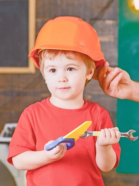 교육 게임 개념입니다. 꼬마 장난감 도구와 함께 연주입니다. 남자 손을 잡고 오렌지 보호 헬멧 — 스톡 사진