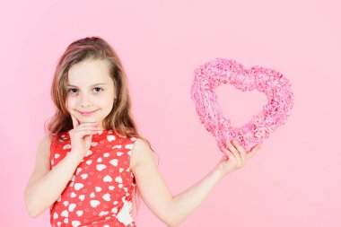Sevgililer günü ve Sevgililer günü kutlama. Mutlu kız pembe pembe kalp tutan. Romantik aşk kavramı. Tatlım Kırmızı elbiseli gülümseyen uzun saçlı çocuk. İyilik ve hassasiyet