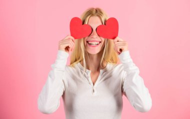 Kız kalp sembolü aşk ve romantik pembe arka plan tutun. Kız neşeli aşık. Aşk kördür. Sevgililer günü geleneksel olarak kadınlar için daha önemli olarak görülmüştür. Kadın aşkı kutluyor