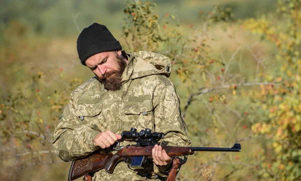 Hunter hold rifle. Aiming skills. Hunting permit. Bearded hunter spend leisure hunting. Hunting equipment for professionals. Hunting is brutal masculine hobby. Man aiming target nature background — Stock Photo, Image