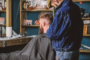 Saç modeli hizmet anlayışı. Kesme makinesi ile kuaför saç modeli sakallı adam, berber arka plan için çalışır. Sakallı hippi istemci saç modeli var. Berber makası veya kesme makinesi ile boyun istemcisinin traş