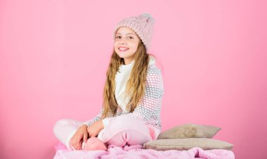Çocuk kız giyim örme yumuşak şapka pembe arka plan. Triko Yıkama sonrası yumuşak tutun. Yumuşak örgü aksesuar. Örme giysiler için bakım için ipuçları. Çocuk uzun saç sıcak yumuşak yünlü şapka zevk yumuşaklık