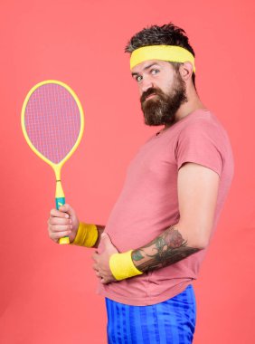 Tenis kilo vermek için etkili bir yol olabilir. Tenis spor. Tenis Kulübü kavramı. Adam hipster giyim eski okul spor kıyafeti bandaj ile sakallı. Elinde kırmızı bir arka plan üzerinde atlet tutun tenis raketi