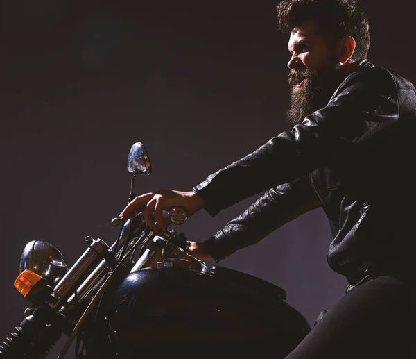 Macho, motociclista brutal em jaqueta de couro andar de moto à noite, espaço cópia. Conceito de masculinidade. Homem com barba, motociclista em jaqueta de couro sentado na moto do motor na escuridão, fundo preto — Fotografia de Stock