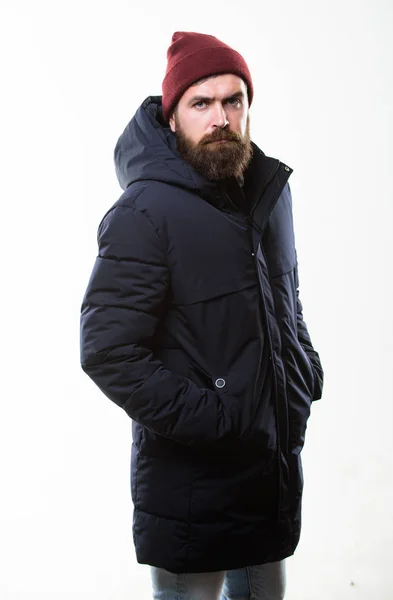 Hipster style menswear. Hipster outfit. Man bearded hipster posing confidently in warm black jacket or parka. Stylish and comfortable. Hipster modern fashion. Guy wear hat and black winter jacket