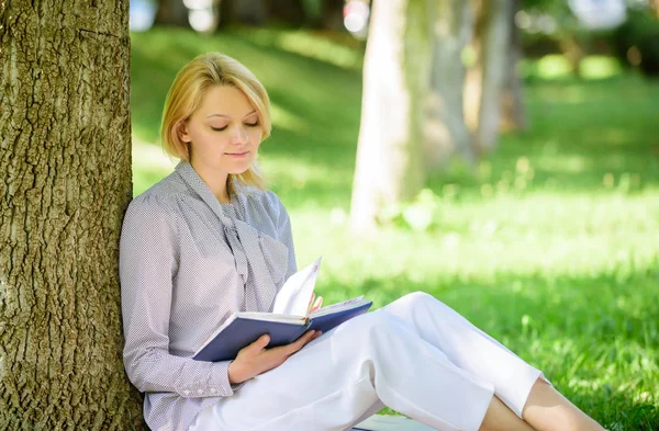 最好的自助书籍的妇女。每个女孩都应该读书。女孩集中坐公园瘦树树干读书。阅读鼓舞人心的书籍。最畅销的名单。放松休闲爱好概念 — 图库照片
