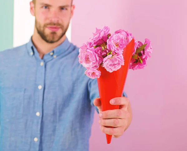 This is for you Macho gives flowers as romantic gift. Boyfriend confident holds bouquet flowers. Guy bring romantic pleasant gift to give. Man ready for romantic date bring bouquet pink flower