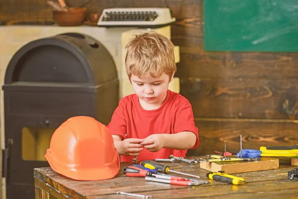 Informelles Bildungskonzept, Lernen durch Spiel. Kind spielt mit Arbeitswerkzeugen. Junge arbeitet mit kleinen Details — Stockfoto