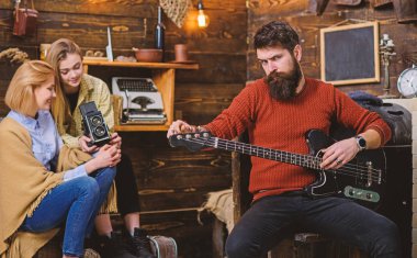 Pişmiş toprak örme kazak ve siyah kot büyük gem taş, moda kavramı ile yüzüğü sakallı adam. Adam elektrik gitarla poz şık sakal ile müzik aletleri promo depolamak.