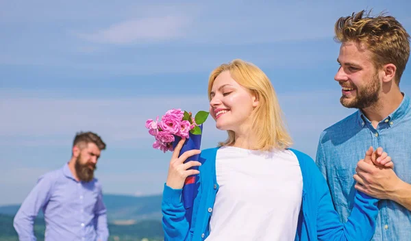 New love. Ex partner watching girl starts happy love relations. Couple in love dating outdoor sunny day, sky background. Ex husband jealous on background. Couple with flowers bouquet romantic date — Stock Photo, Image