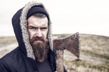 Sakallı yakışıklı ciddi adam dağ üstüne paslı balta ile