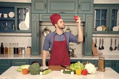 Yakışıklı beyaz delikanlı önlük sebze ile masada