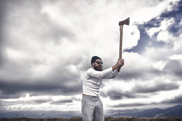 Хипстер бородатый дровосек в солнечных очках, с топором для поднятия шляпы
