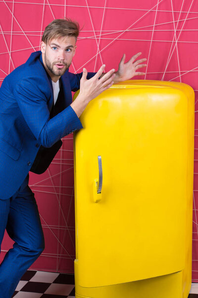 сексуальный мужчина в стильной куртке. уверенный бизнесмен в костюме. Бизнесмен. Несчастный человек. Почувствуй успех. Мужская формальная мода. Яркий холодильник бытовой техники. предметы интерьера