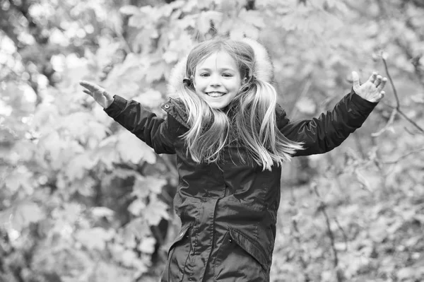 Bequem und unbeschwert. Kinderblonde lange Haare laufen in warmer Jacke im Freien. Mädchen glücklich in rotem Mantel genießen Herbst Naturpark. Kinder tragen modische Jacke mit Kapuze. Herbstbekleidung und Modekonzept — Stockfoto