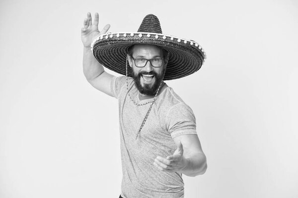 Mexican party concept. Man cheerful happy face in sombrero hat celebrating yellow background. Guy with beard looks festive in sombrero. Party and holiday concept. Mexican traditional attribute