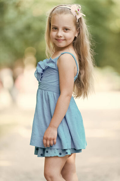 small baby girl with smiling face in blue dress outdoor