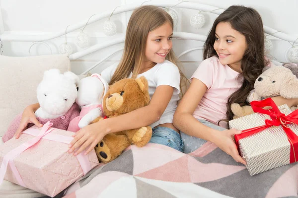 Dying to open these exciting presents. Small girls with presents in bed. Opening presents on Christmas eve. Happy small children hold gift boxes. New Year surprise. Merry Christmas and Happy New Year — Stock Photo, Image