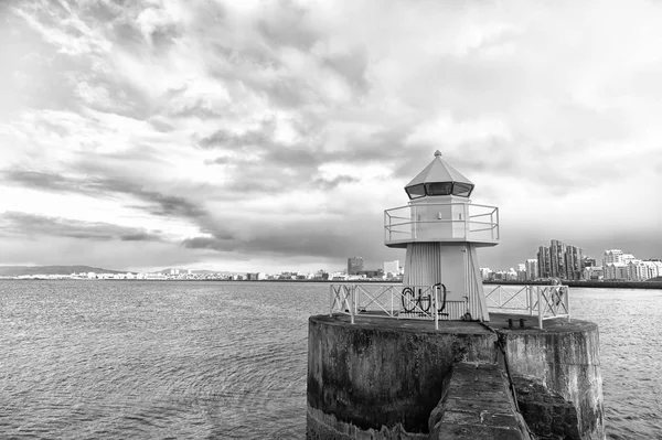 Faro en el muelle del mar en reykjavik iceland. Faro amarillo brillante torre en la orilla del mar. Concepto de navegación por puerto marítimo. Transporte marítimo y navegación. Paisaje marino y horizonte con faro luminoso —  Fotos de Stock