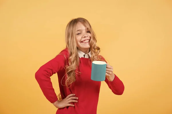 Girl with long blond hair in red sweater hold mug