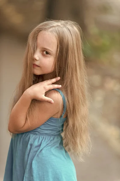 Pequena menina com cabelo comprido no vestido azul ao ar livre — Fotografia de Stock