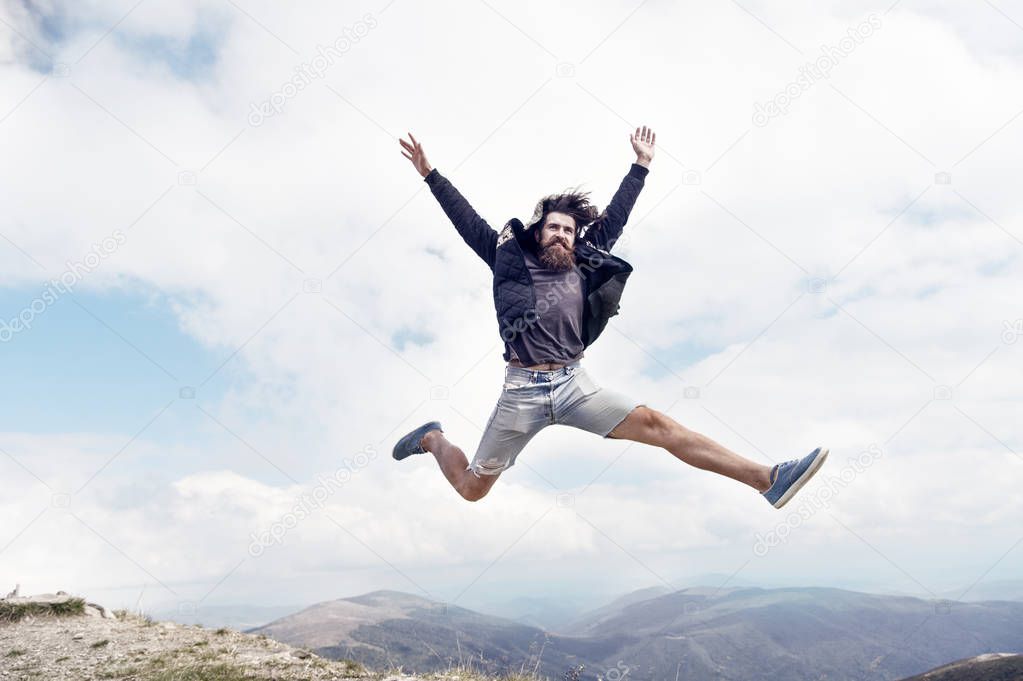 bearded man, brutal caucasian hipster with moustache jump on mountain