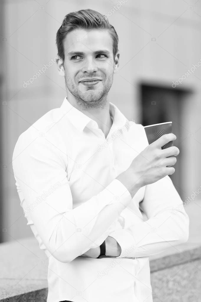 Man manager elegant shirt enjoy coffee urban background. Businessman elegant guy drink tea or coffee. Break for relax and recharge energy caffeine beverage. Have cup of coffee. He prefer coffee to go