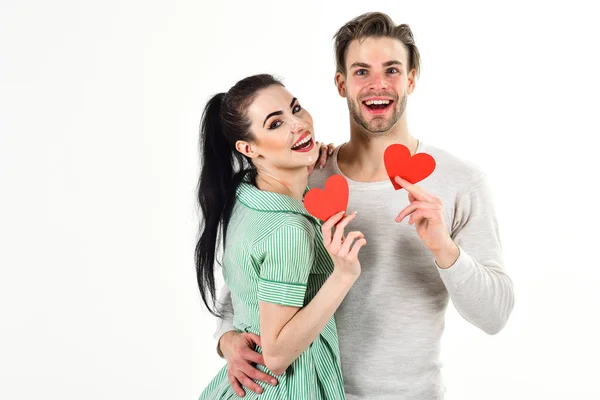 Valentines day and love. Man and woman couple in love hold red heart card on white background. Romantic couple in love hug. Handsome unshaven man and pretty girl in love. Romantic feelings concept — Stock Photo, Image