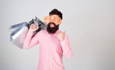 Adam çok alışveriş torbaları ile sakallı hippi. Üstünde siyah Cuma alışveriş. Mutlu grup kağıt torbalar ile alışveriş. Karlı bir anlaşma. Alışveriş bağımlısı tüketici. Gelecek tatilinizi için hazır almak nasıl