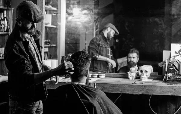 Reflexión de peluquero peinado pelo de cliente barbudo con peine. Hipster cliente conseguir peinado. Concepto de barbería. Hombre con barba y bigote en silla de peluquero delante del fondo del espejo — Foto de Stock