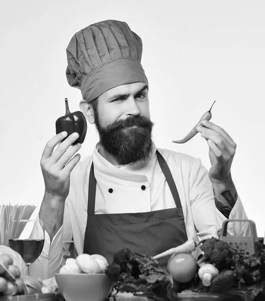 Laga mat med flörtigt ansikte i uniform sitter vid köksbordet — Stockfoto
