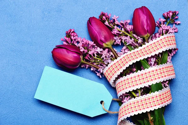 Etiqueta azul ciano com tulipas rosa e flores lilás — Fotografia de Stock