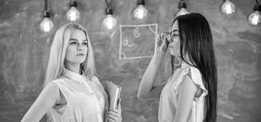 Çekici öğretmen sınıfları sonra overworking. Bayanlar özel ders, kara tahta arka plan başlamak için hazır. Kitap ve çekici görünümlü gözlük ile formal giyim öğretmenler. Özel ders kavramı