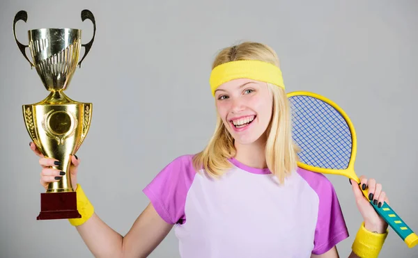 Le donne indossano abiti sportivi. Primo posto. Risultati sportivi. Festeggia la vittoria. Campione di tennis. Ragazza atletica tenere racchetta da tennis e calice d'oro. Vincere una partita di tennis. Giocatore di tennis vincere il campionato — Foto Stock