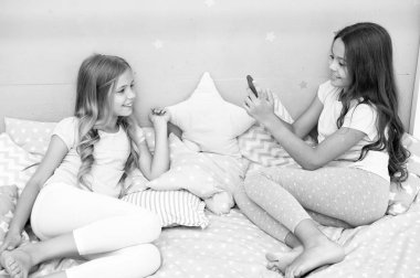 Selfie modelleme çocuk - iki küçük kız selfie smartphone yapma. küçük kızlar çocuklar yatak odasında modelleme. Onun tarzı güvenen.