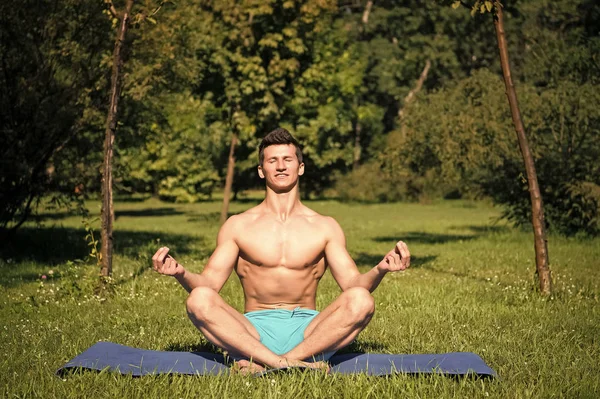 Man met gezond lichaam mediteren op yoga mat — Stockfoto