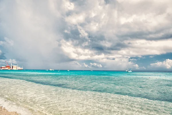 Meer mit Booten und Hafen in Grand Turk, Turks und Caicos Inseln. Meereslandschaft mit türkisfarbenem Wasser am bewölkten Himmel. Sommerurlaub auf der tropischen Insel. Entdeckungen, Abenteuer und Fernweh — Stockfoto