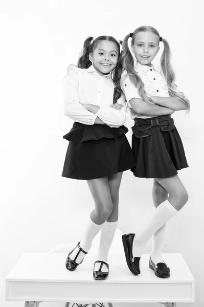 Le ragazze felici sorridono in uniforme scolastica. Torniamo a scuola. Bei vestiti riccioli, grazie al cielo per le bambine — Foto Stock