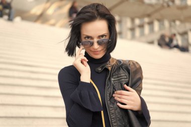 Paris, Fransa ve güzellik merdivenlerinde güneş gözlüklü şehvetli bir kadın. Siyah elbiseli, esmer saçlı kadın, moda. Hırs, meydan okuma, başarı. Moda, aksesuar, tarz. Güzellik, bak, saç stili.