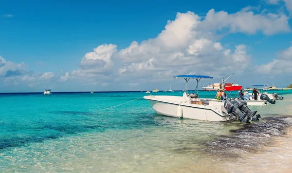 Grand Turk, Turks a Caicos - 29 prosinec 2015: motorové čluny a lidé na pláži moře. Powerboats na slunné scenérií. Cestování na lodi, vodní doprava. Letní dovolená na tropickém ostrově — Stock fotografie